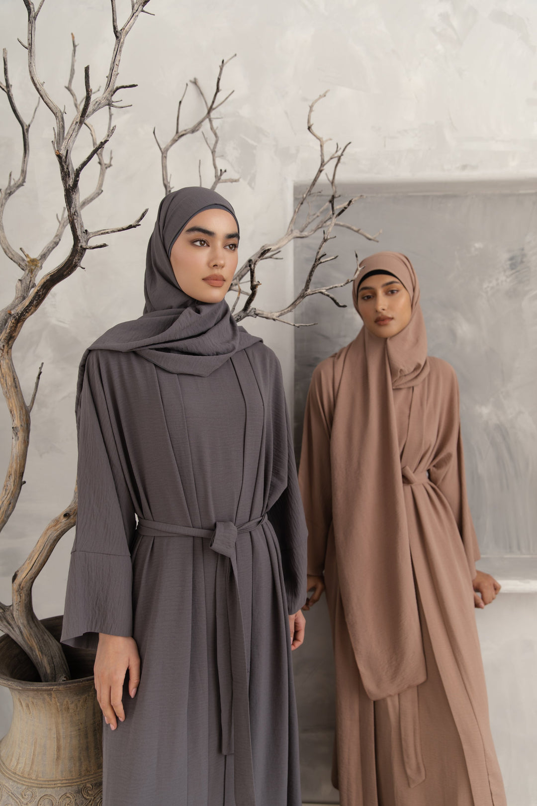 Two women in modest dresses and hijabs wearing a Gray Four Piece Open Abaya Set