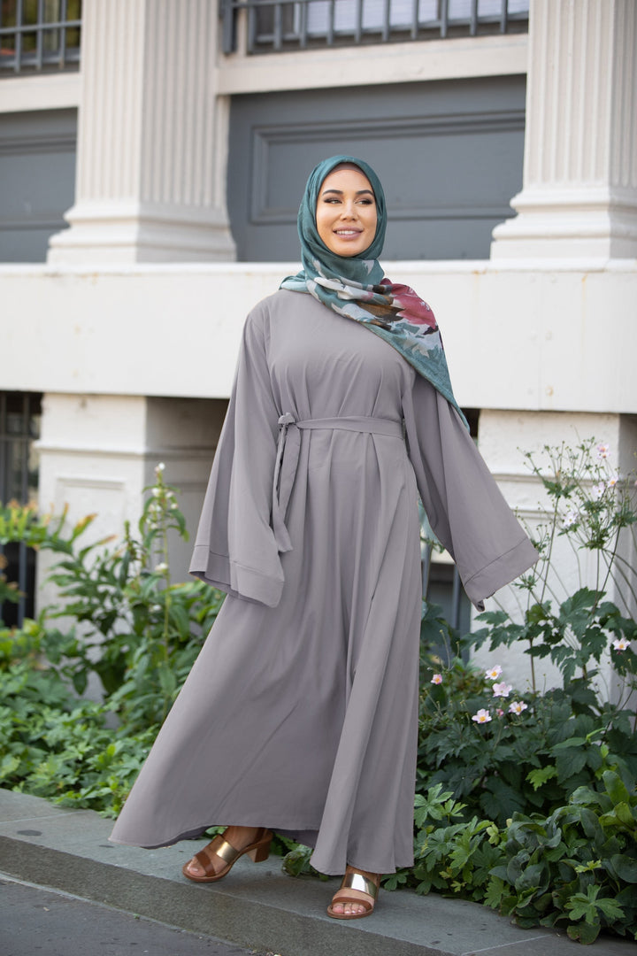 Woman wearing a Gray Kimono Sleeve Abaya Maxi Dress with fabric tie belt and patterned hijab