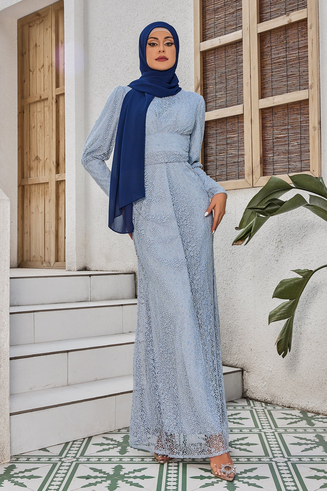 Woman in a light blue lace ruched waist long sleeve gown and dark blue hijab