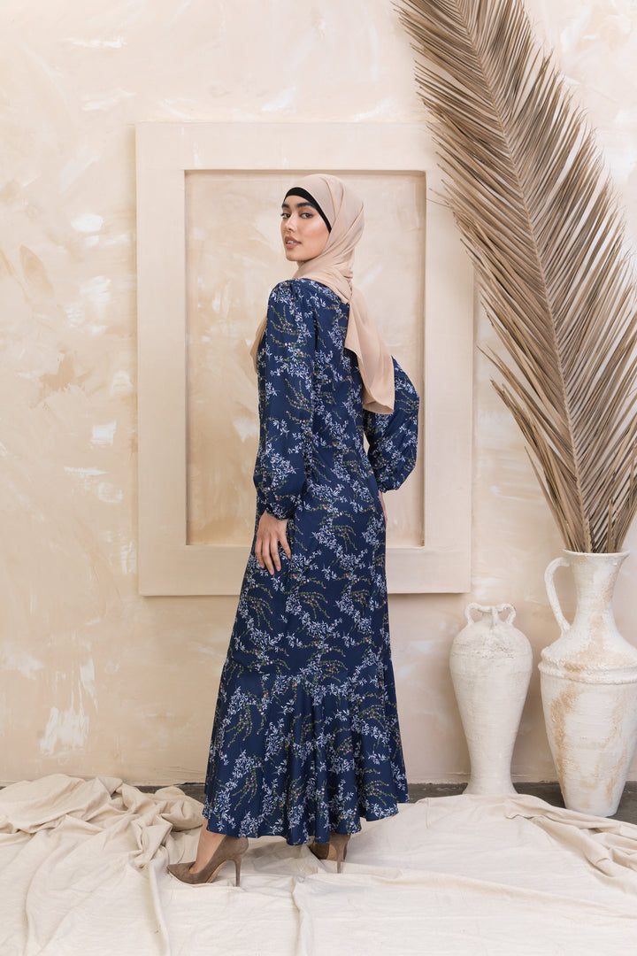 Woman in a long-sleeved hijab presenting Heavenly Blue Floral Ruffle Faux Wrap Maxi Dress