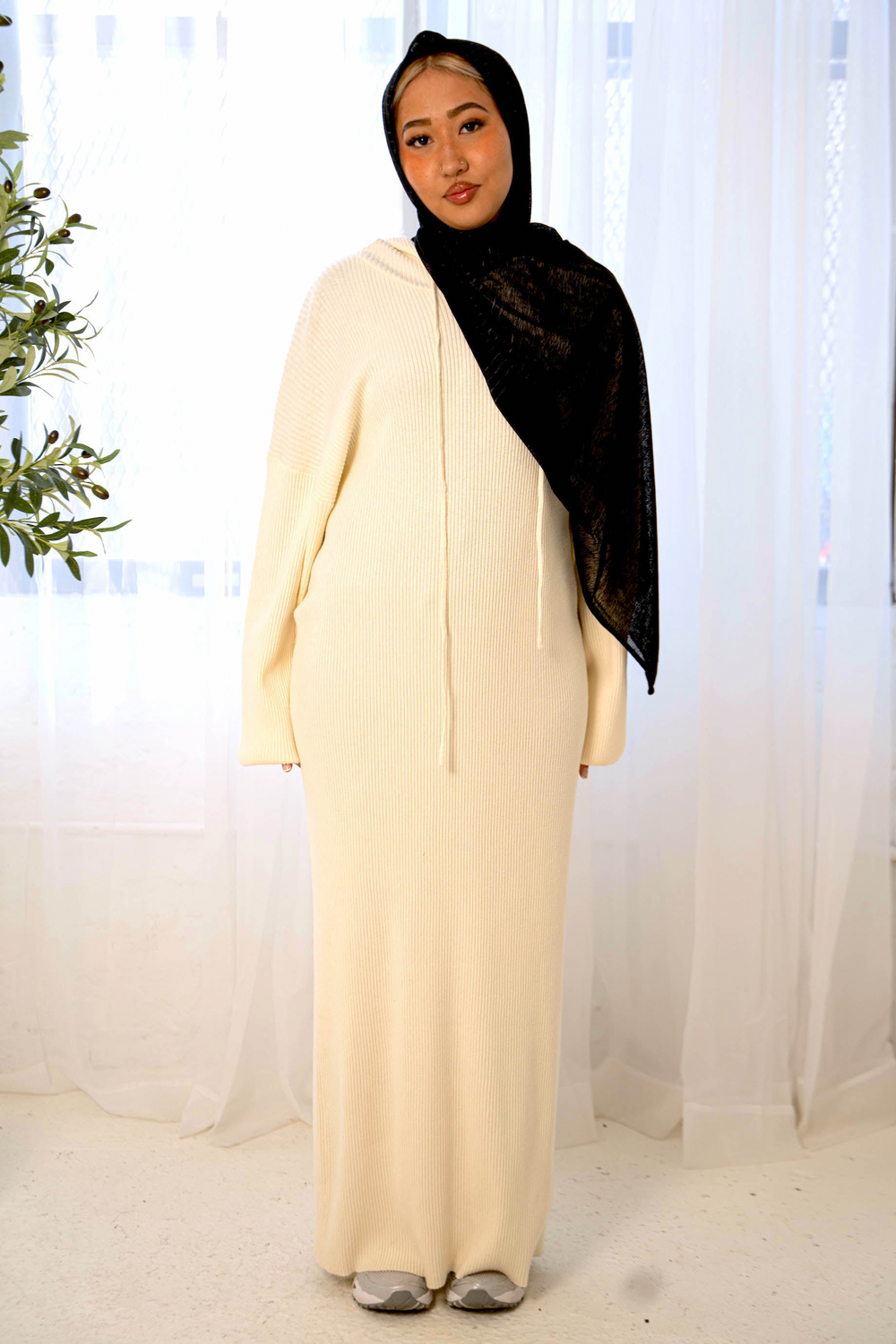 Woman in a cream hoodie ribbed sweater dress and black hijab, stylish and comfortable