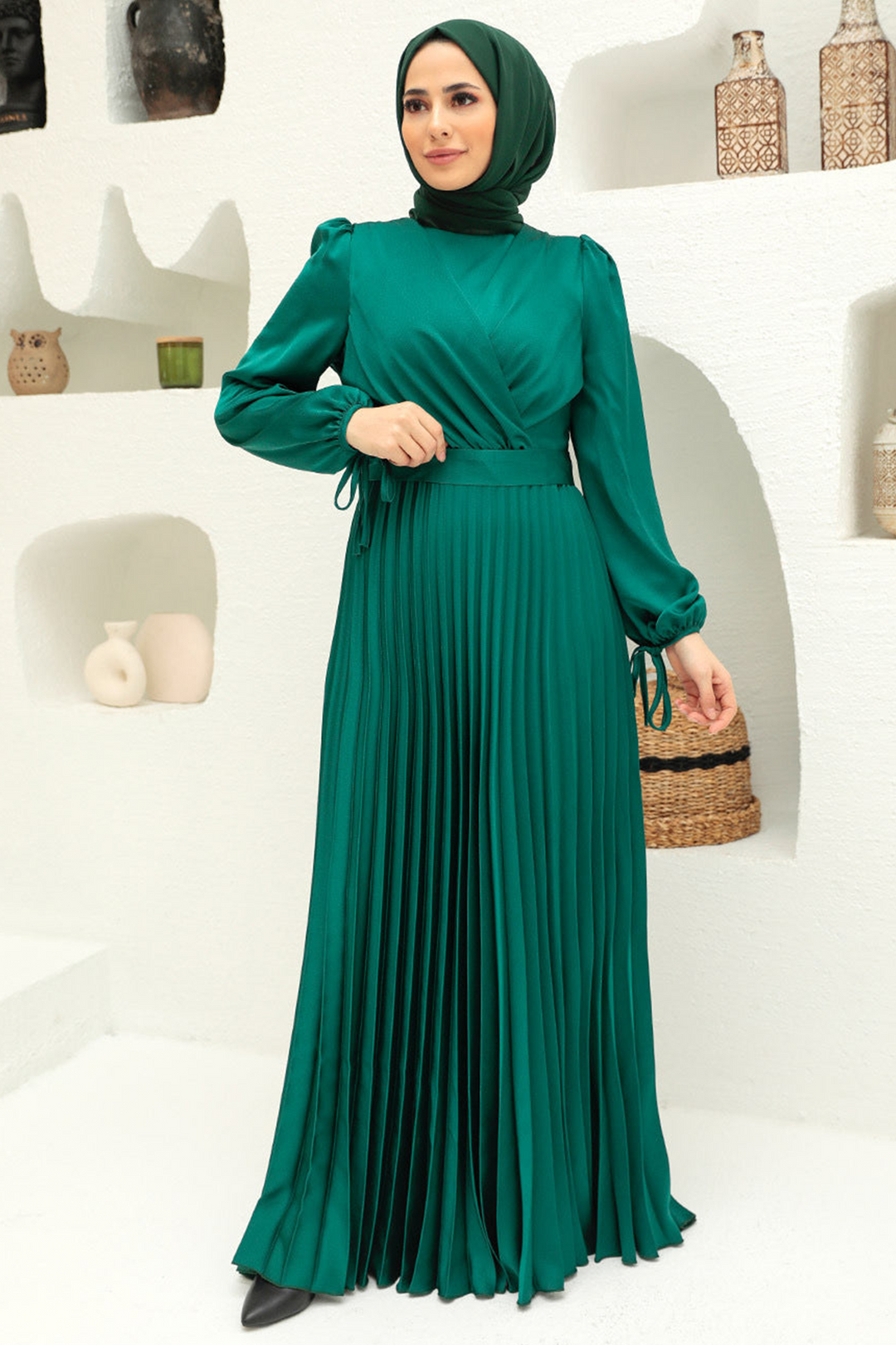 Emerald green criss cross pleated satin gown showcasing elegant design and style