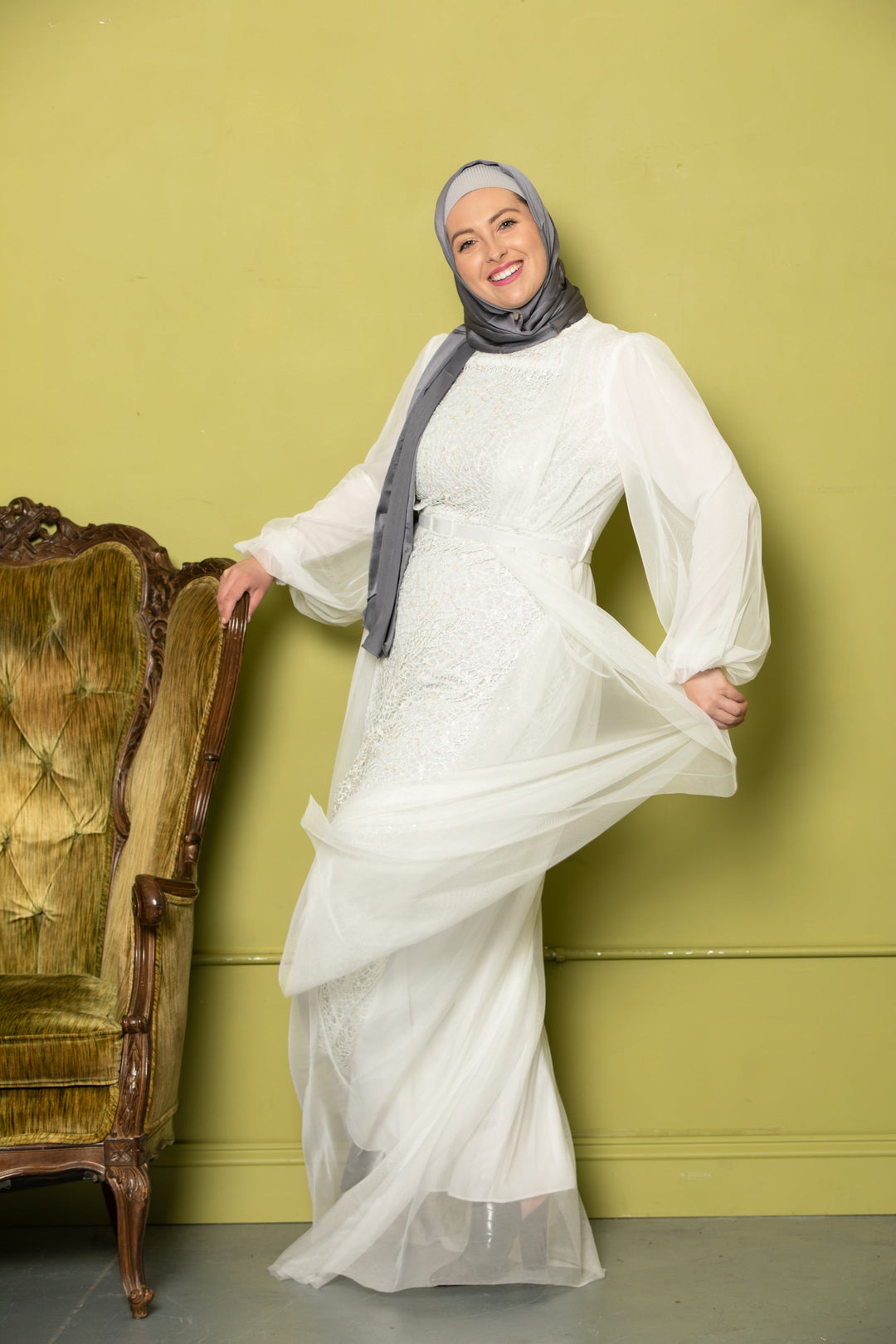 Smiling woman in white dress with gray hijab showcasing Ivory Lace Chiffon Overlay Gown