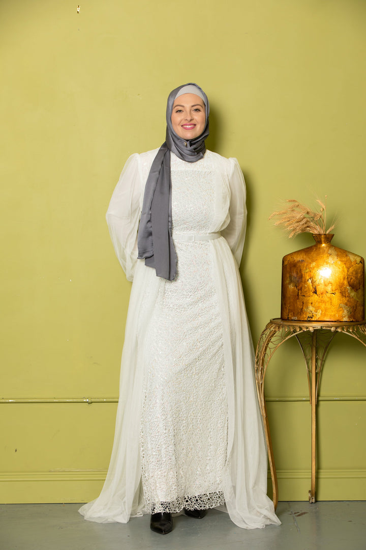 Woman in a white dress and gray hijab showcasing an Ivory Lace with Chiffon Overlay Gown