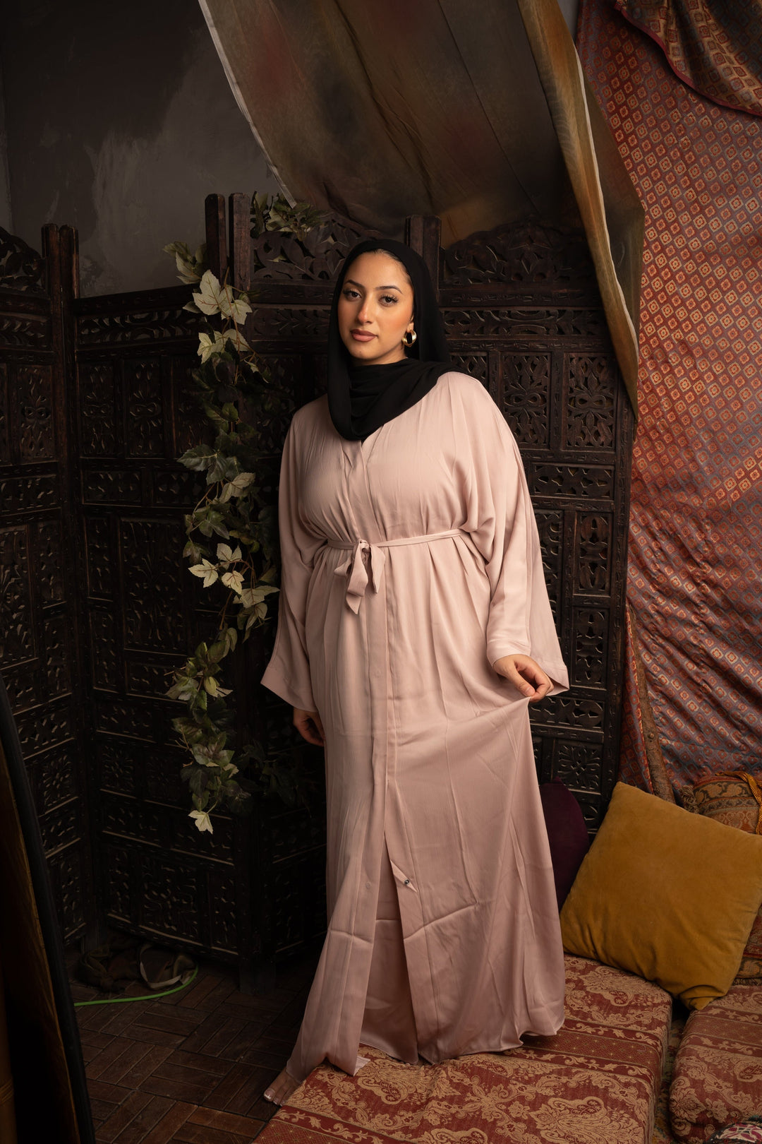 Woman in a light pink open abaya showcasing the Khaki Sleeveless Dress and Abaya Set