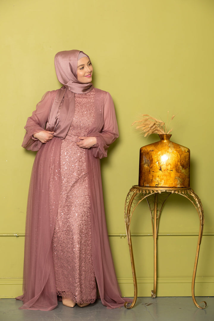 Woman in a mauve chiffon overlay gown with hijab, showcasing elegance and style