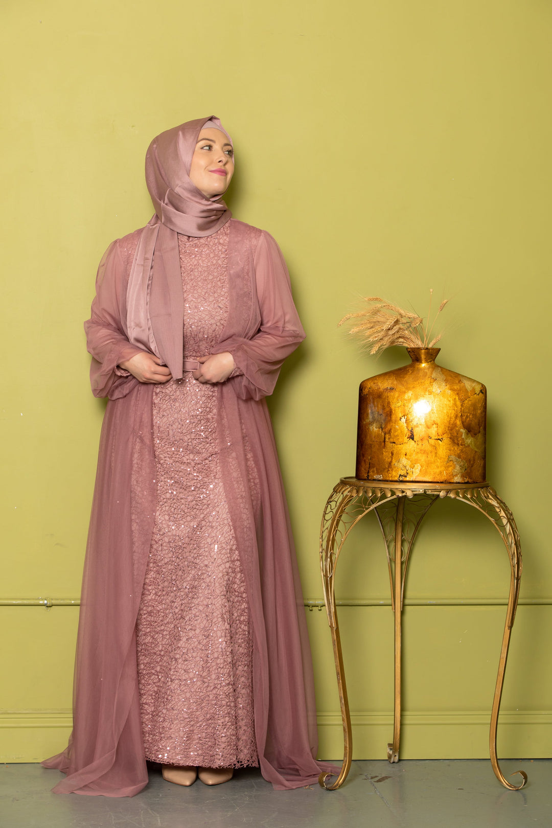 Woman in a mauve sequined dress with hijab wearing a chiffon overlay gown