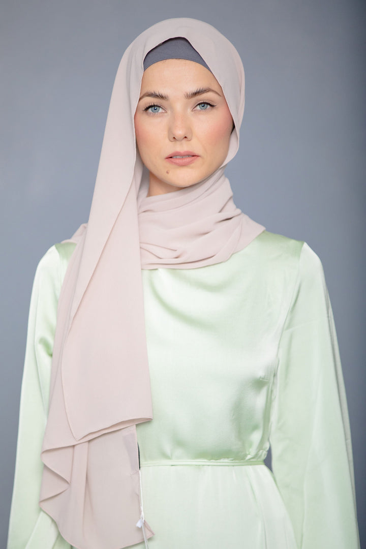 Woman in a Latte Chiffon Hijab paired with a flowing light green maxi dress