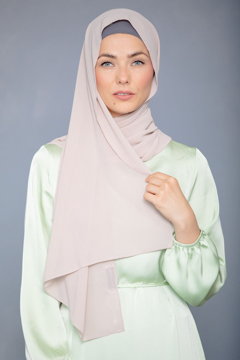 Woman in light-colored chiffon scarf and maxi dress, showcasing Latte Chiffon Hijab