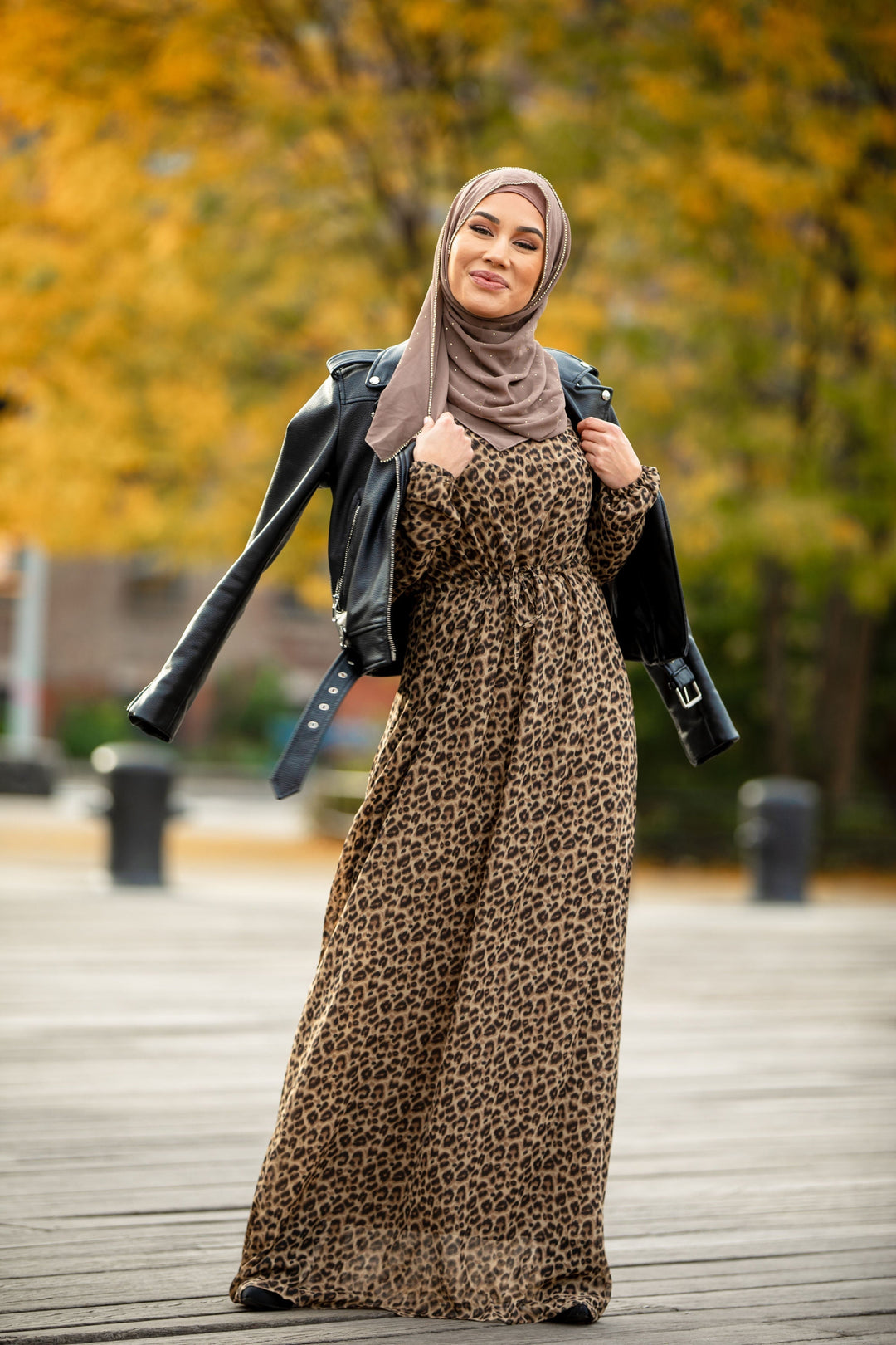 Woman styled in a leopard print maxi dress with elastic cuffs and hijab