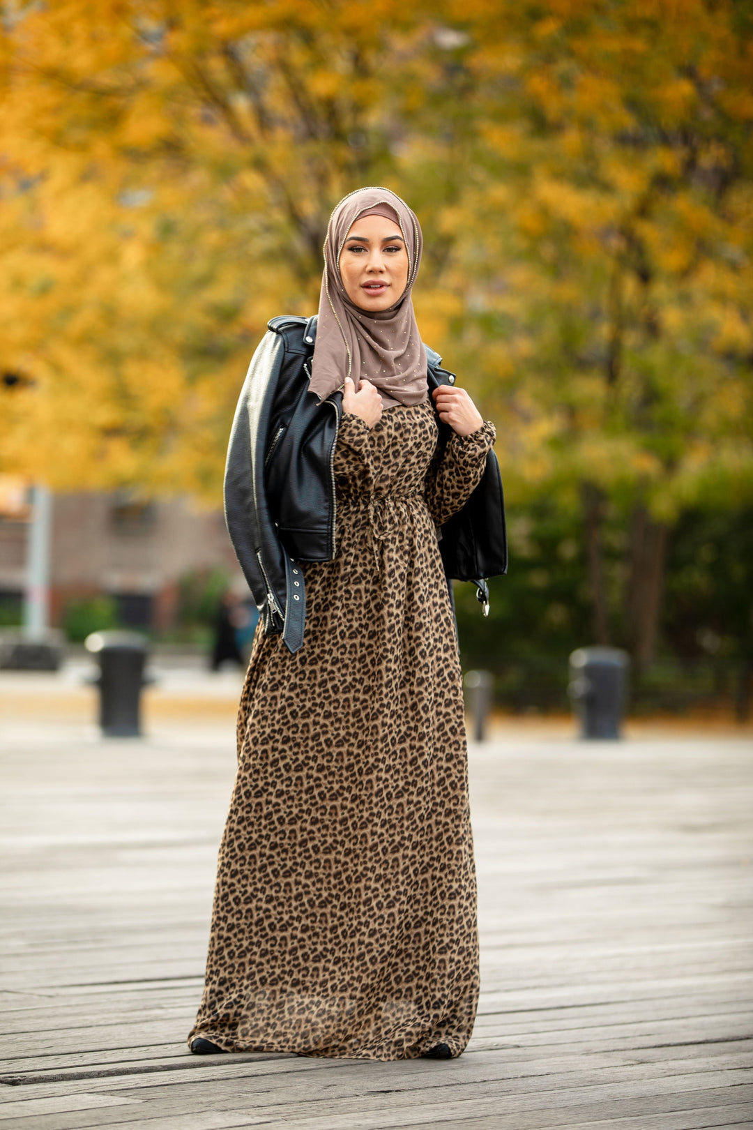 Woman in leopard print maxi dress with elastic cuffs and hijab styled elegantly