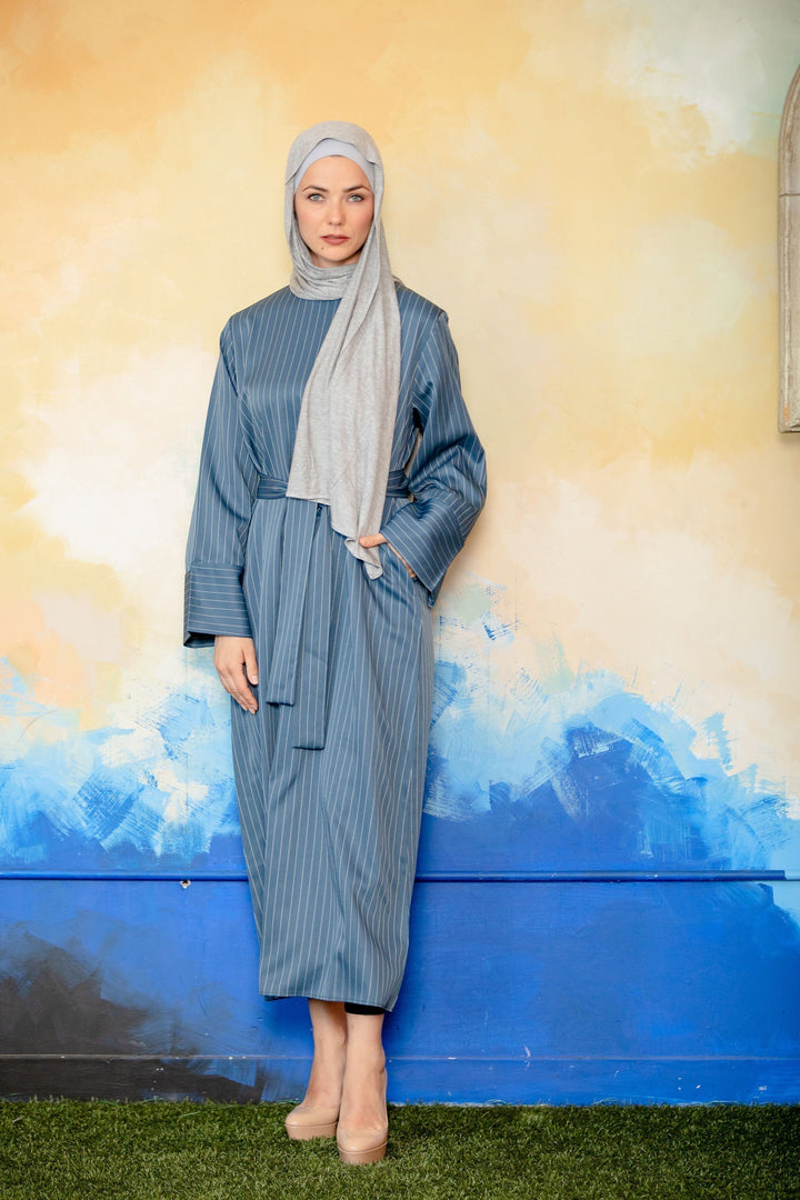 Woman in blue pinstripe kimono sleeve abaya showcasing lightweight fashion style