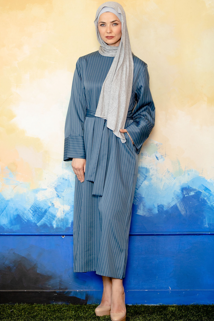 Woman in a blue pinstripe kimono sleeve abaya showcasing stylish modest fashion