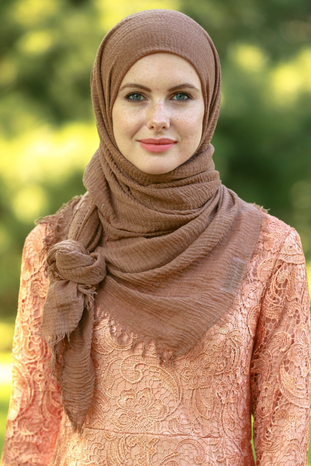 Woman in brown hijab and peach lace dress, showcasing a Light Brown Cotton Hijab Head Scarf