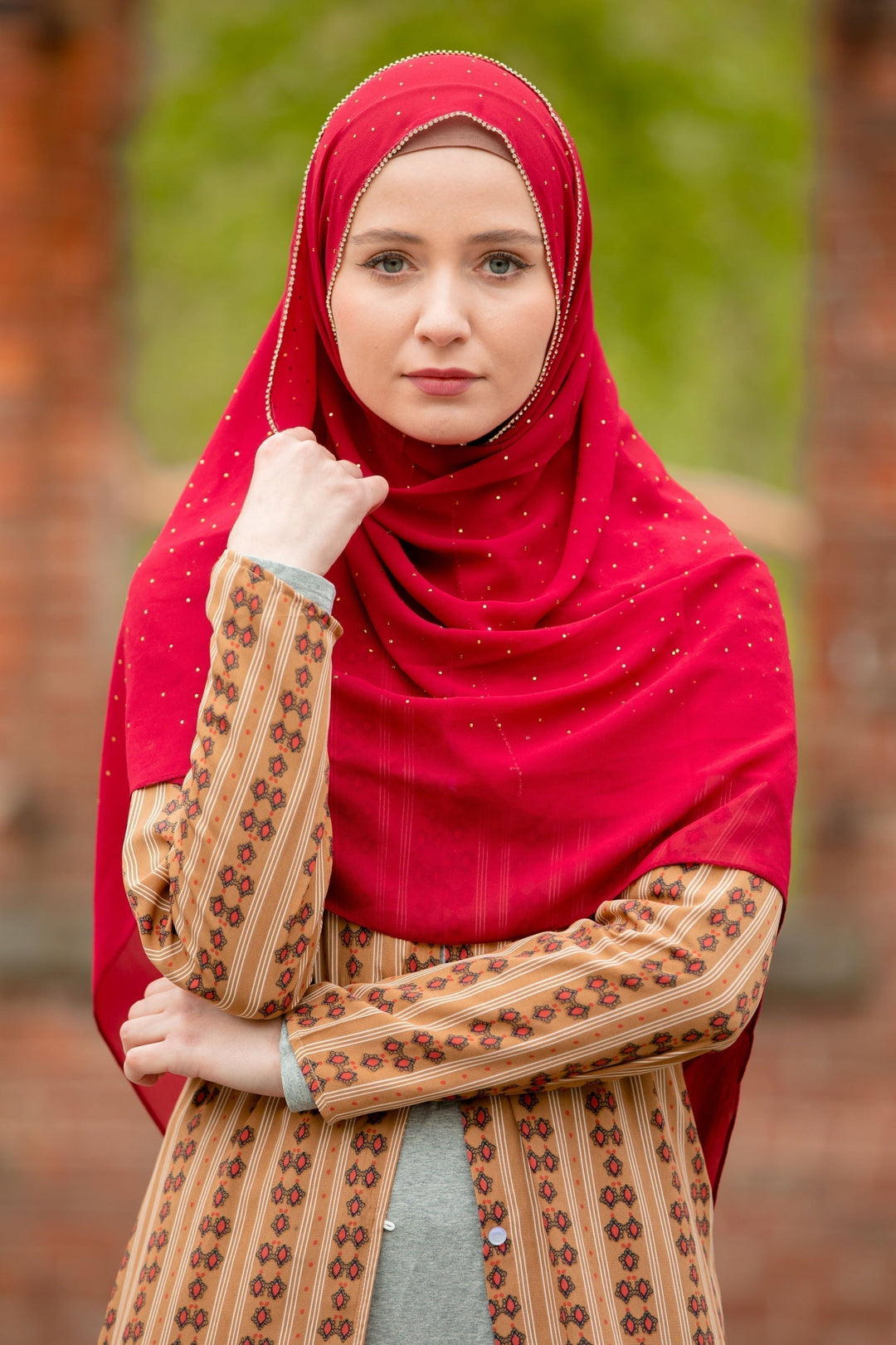 Woman in a red hijab and patterned tunic showcasing a Maroon Beaded Chiffon Hijab