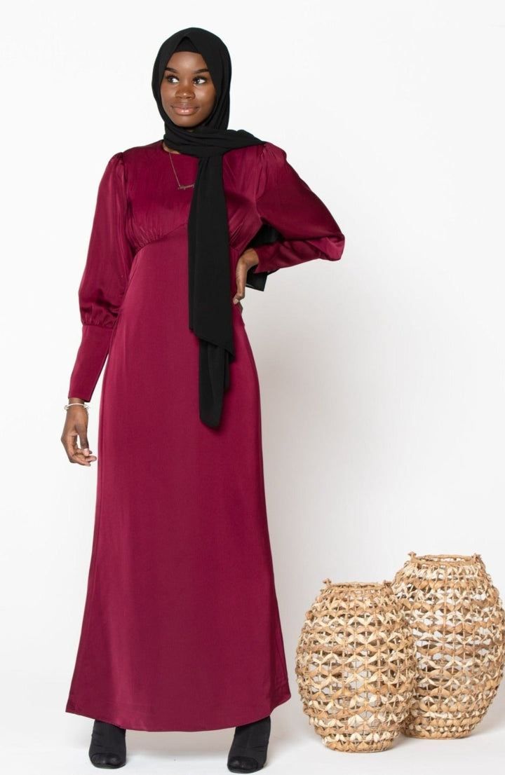 Burgundy satin long sleeve maxi dress paired with a black hijab for stylish modesty