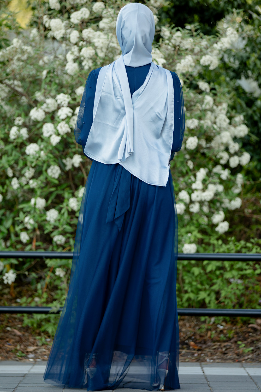 Woman in a blue Mesh Pearl Long Sleeve Gown with a headscarf, showcasing elegance