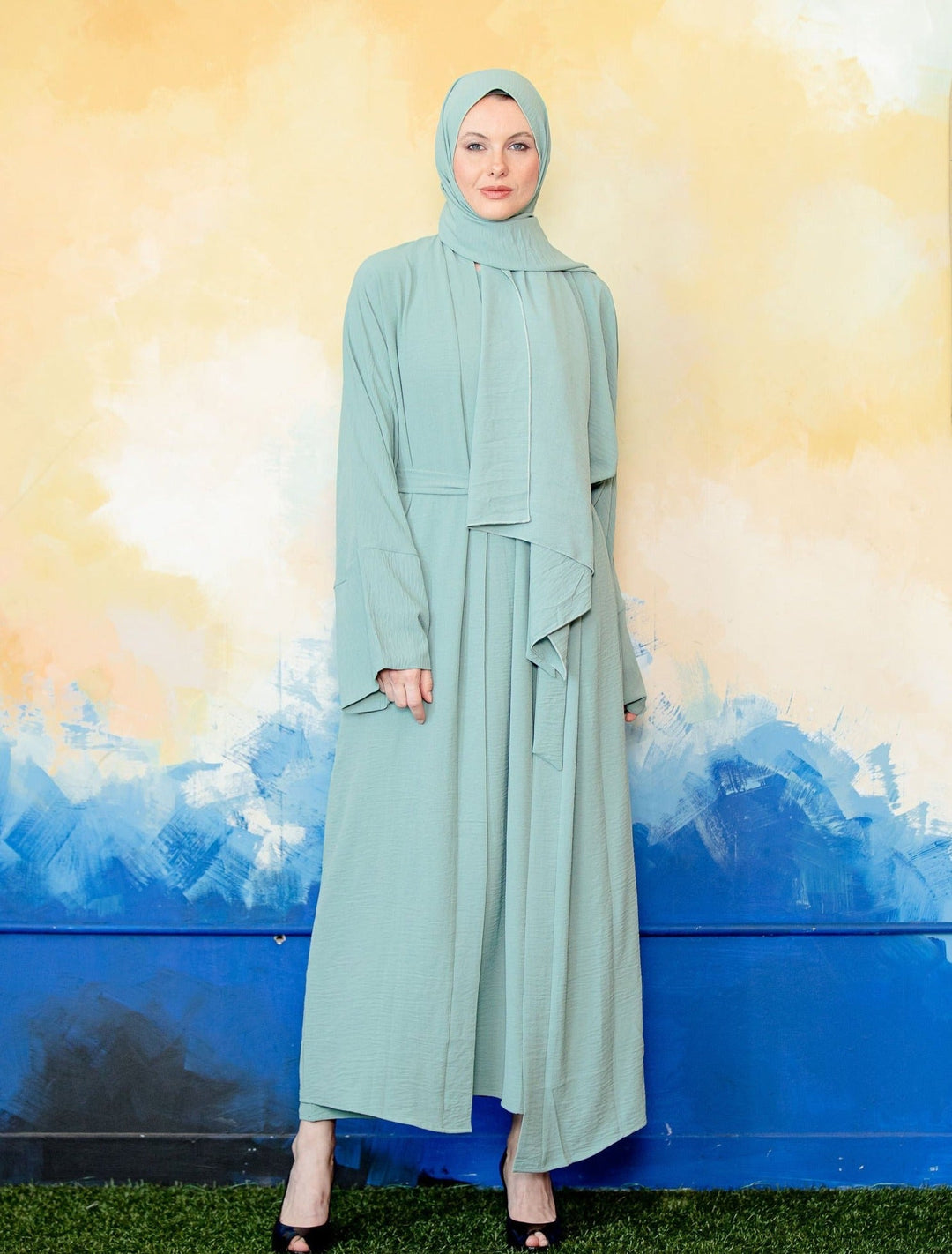 Woman in a light green hijab and dress showcasing Mint Four Piece Open Abaya Set