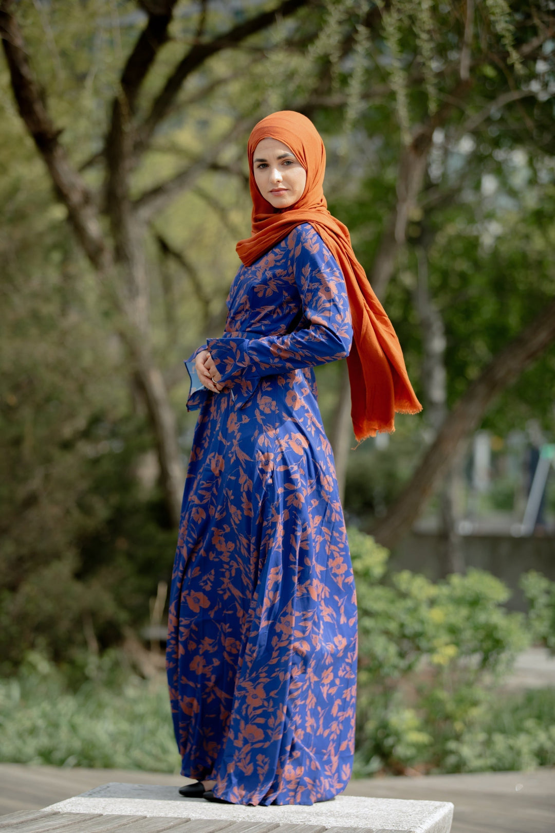 Woman in blue floral dress and orange hijab wearing Caramel Flutter Long Sleeve Maxi Dress