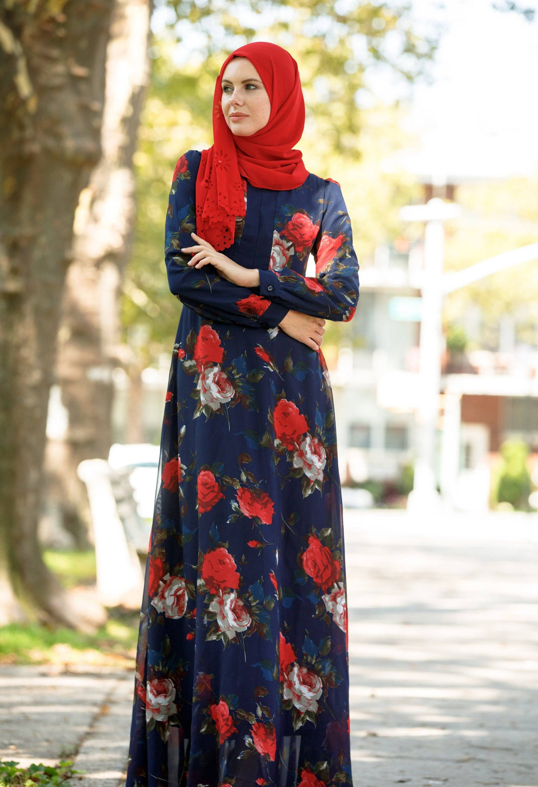 Woman in a floral maxi dress and red hijab representing urban modesty in stylish attire