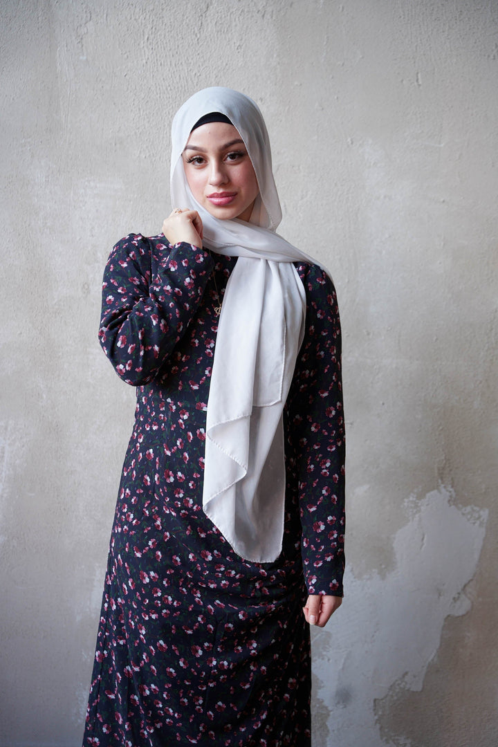 Woman in floral dress and hijab showcasing Navy Floral Ruched Maxi Dress with adjustable ruching