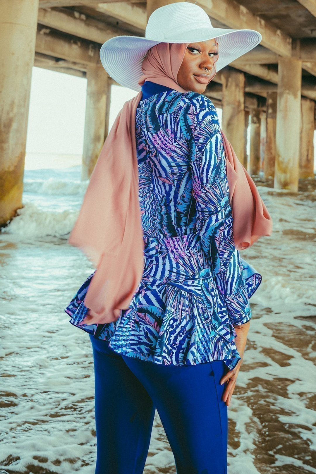 Woman wearing a Navy Floral Ruffle 3 Piece Modest Swimsuit with a hijab and sun hat