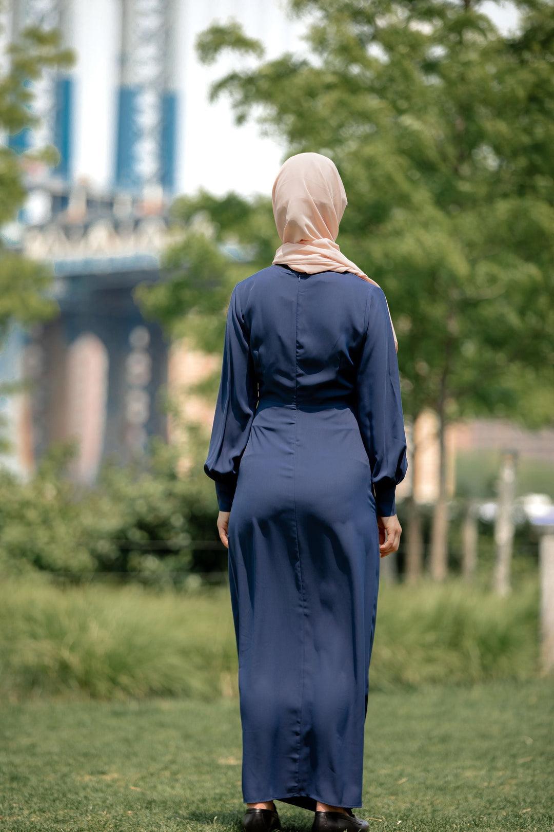 Woman in a long blue wrap maxi dress with criss cross neckline for CLEARANCE sale