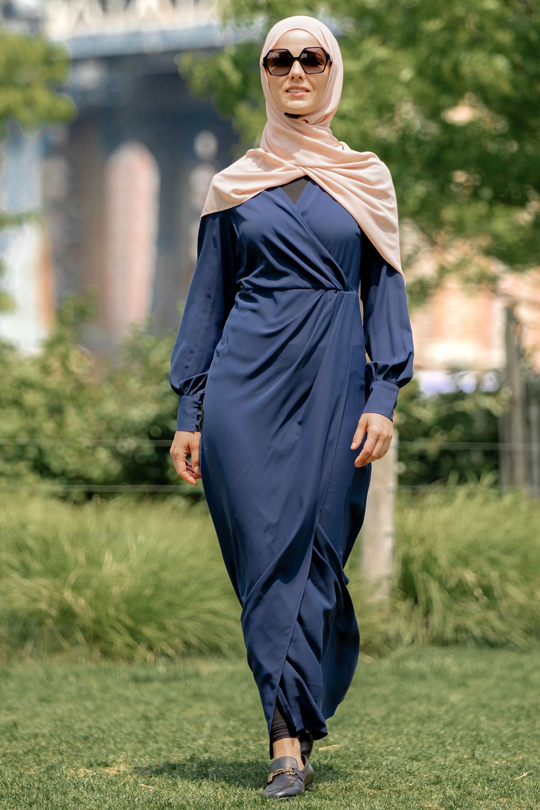 Woman in a navy blue dress and hijab modeling the Navy Wrap Maxi Dress on clearance