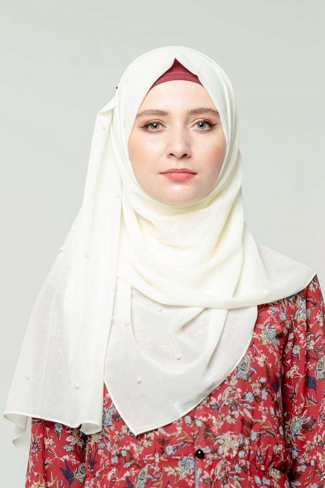 Woman in a white pearl chiffon hijab paired with a floral dress