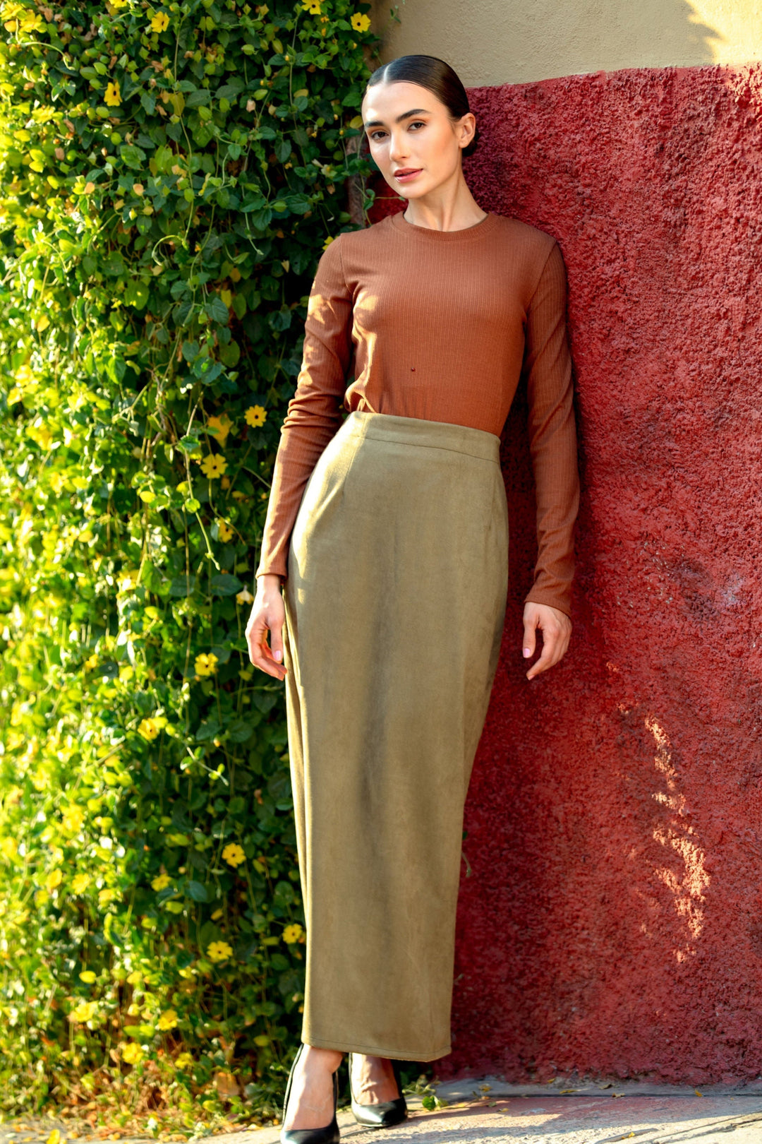 Woman wearing olive green suede pencil maxi skirt, showcasing stylish outfit