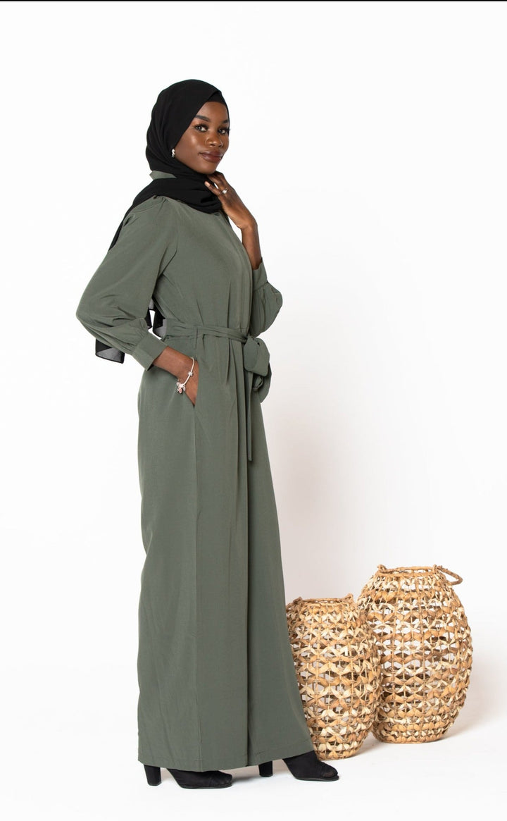 Olive green jumpsuit with long sleeves paired with a black hijab for modest fashion