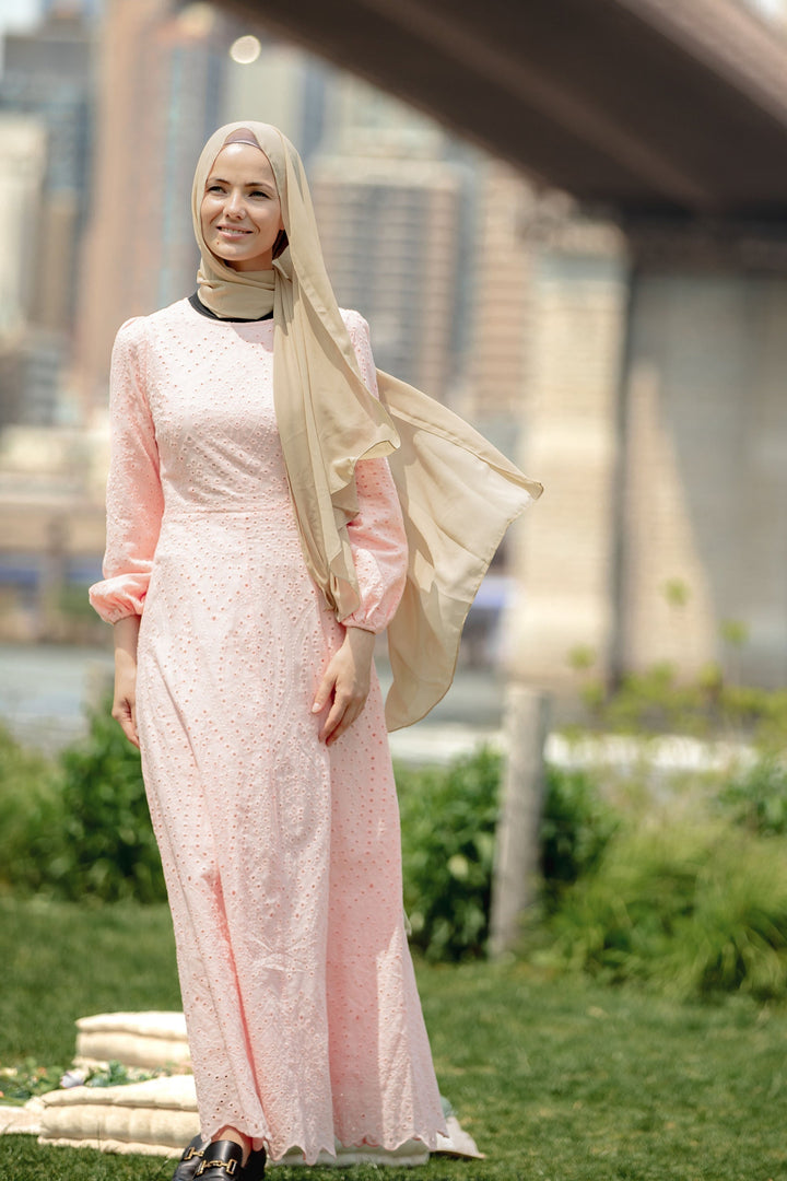 Woman in a pink dress and hijab wearing a Peach Eyelet Long Sleeve Maxi Dress