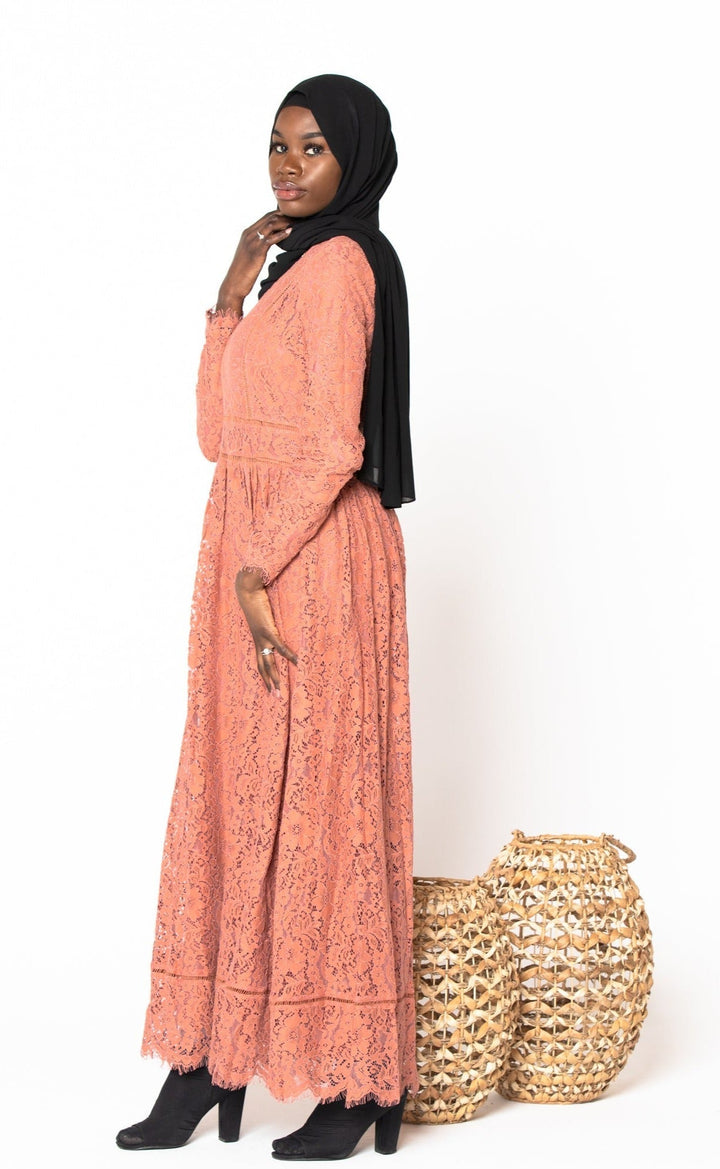 Woman in a peach Zahra Lace Long Sleeve Maxi Gown with black hijab, featuring zipper closure