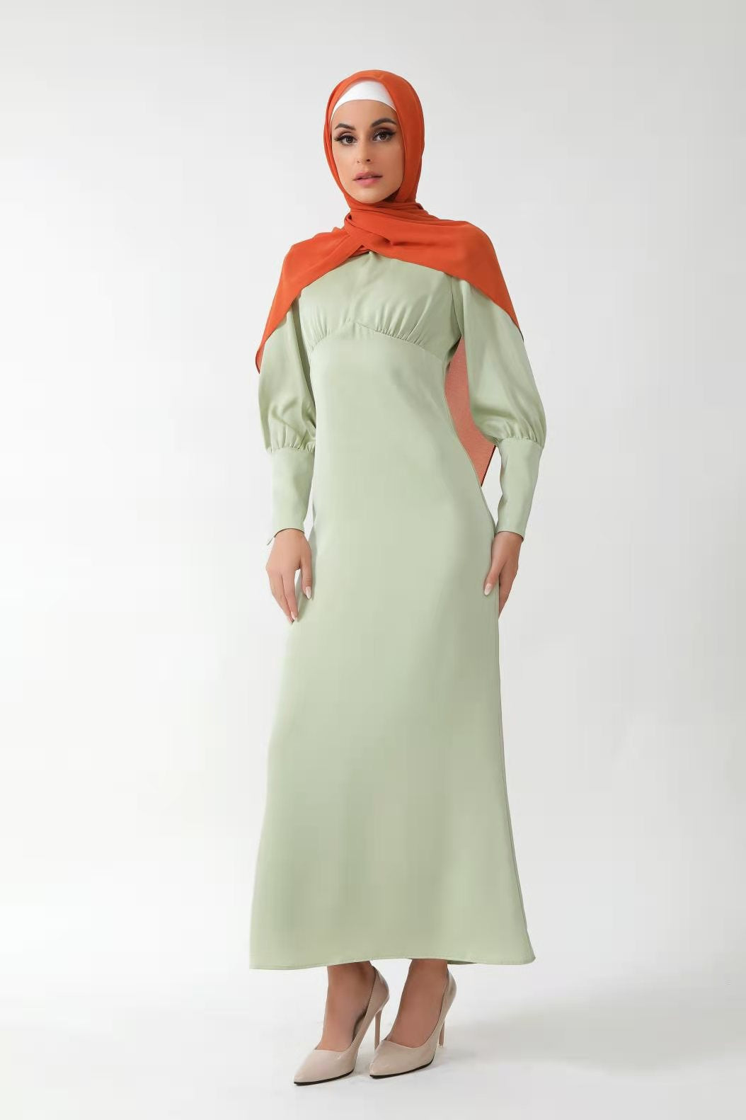 Woman in a Pistachio Satin Long Sleeve Maxi Dress with batwing sleeves and hijab