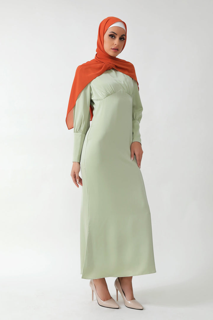 Woman wearing a Pistachio Satin Long Sleeve Maxi Dress with batwing sleeves and hijab