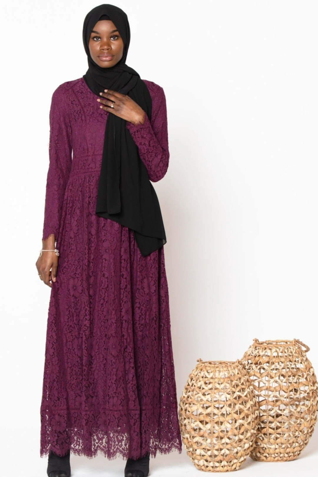 Woman in a maroon Zahra Lace gown with long sleeves and a black hijab, featuring zipper closure