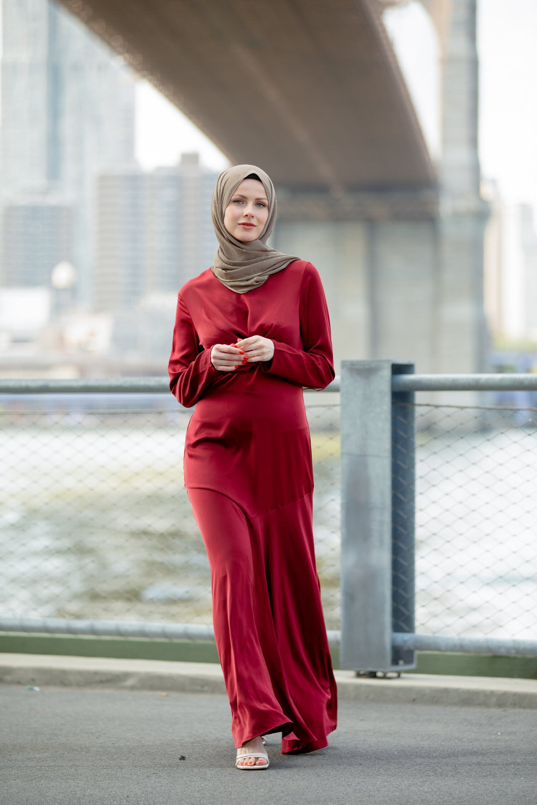 Woman in a red dress with hijab showcasing the Red Criss Cross Satin Maxi Dress