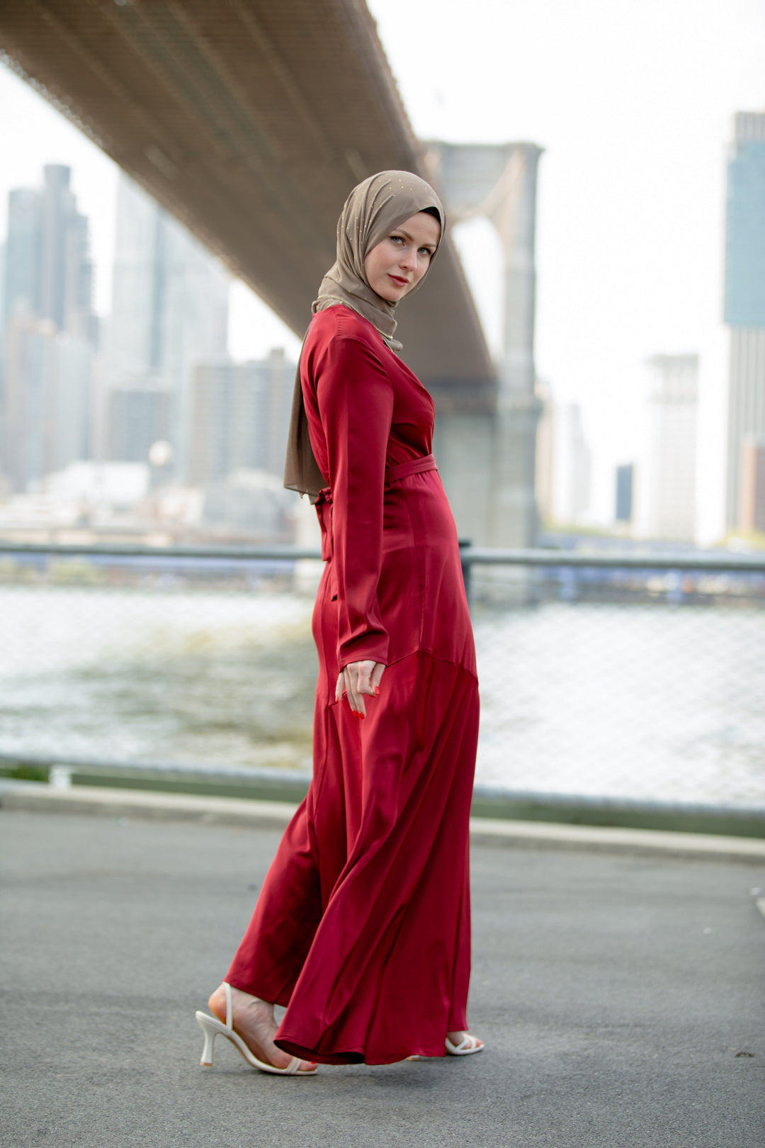 Woman in red dress with hijab showcasing Red Criss Cross Satin Maxi Dress on clearance