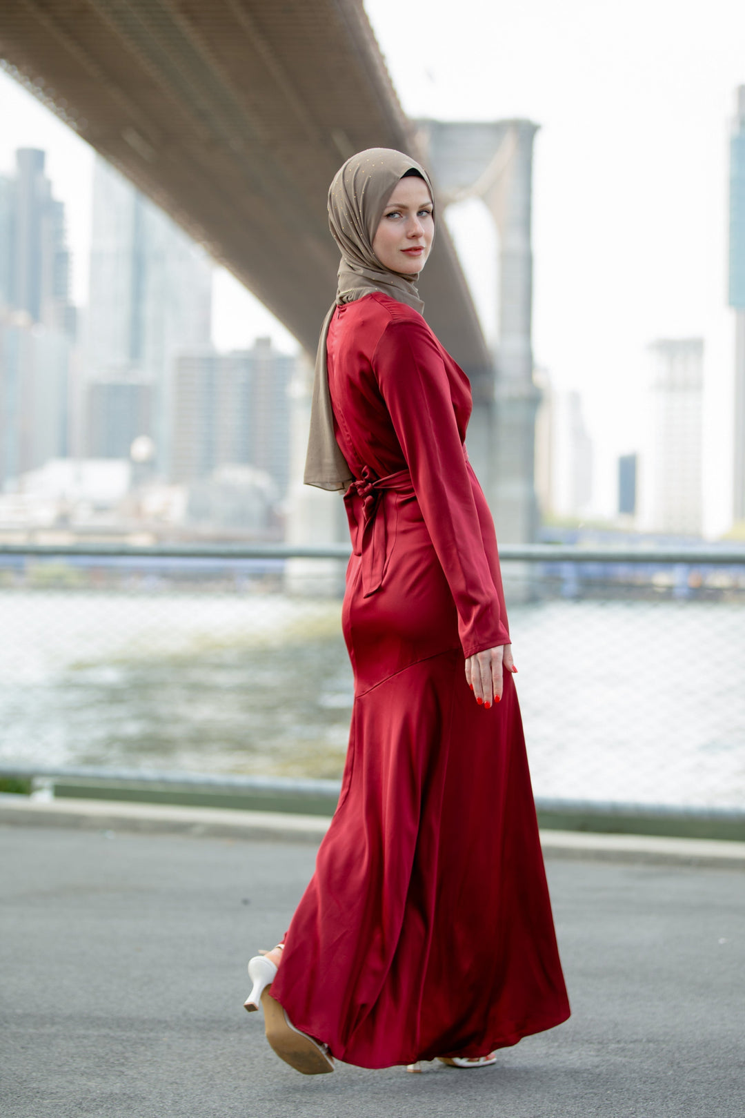 Woman in a red criss cross satin maxi dress with hijab showcasing cross wrap waist