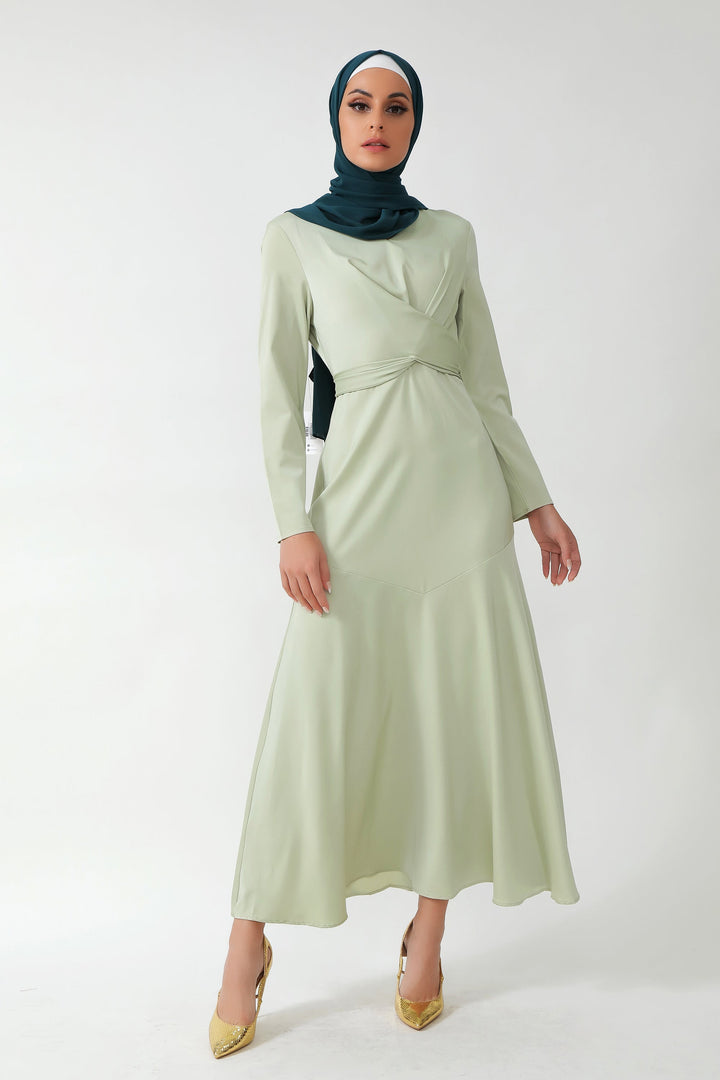 Woman in a light green dress and dark green hijab showcasing Sage Green Criss Cross Satin design