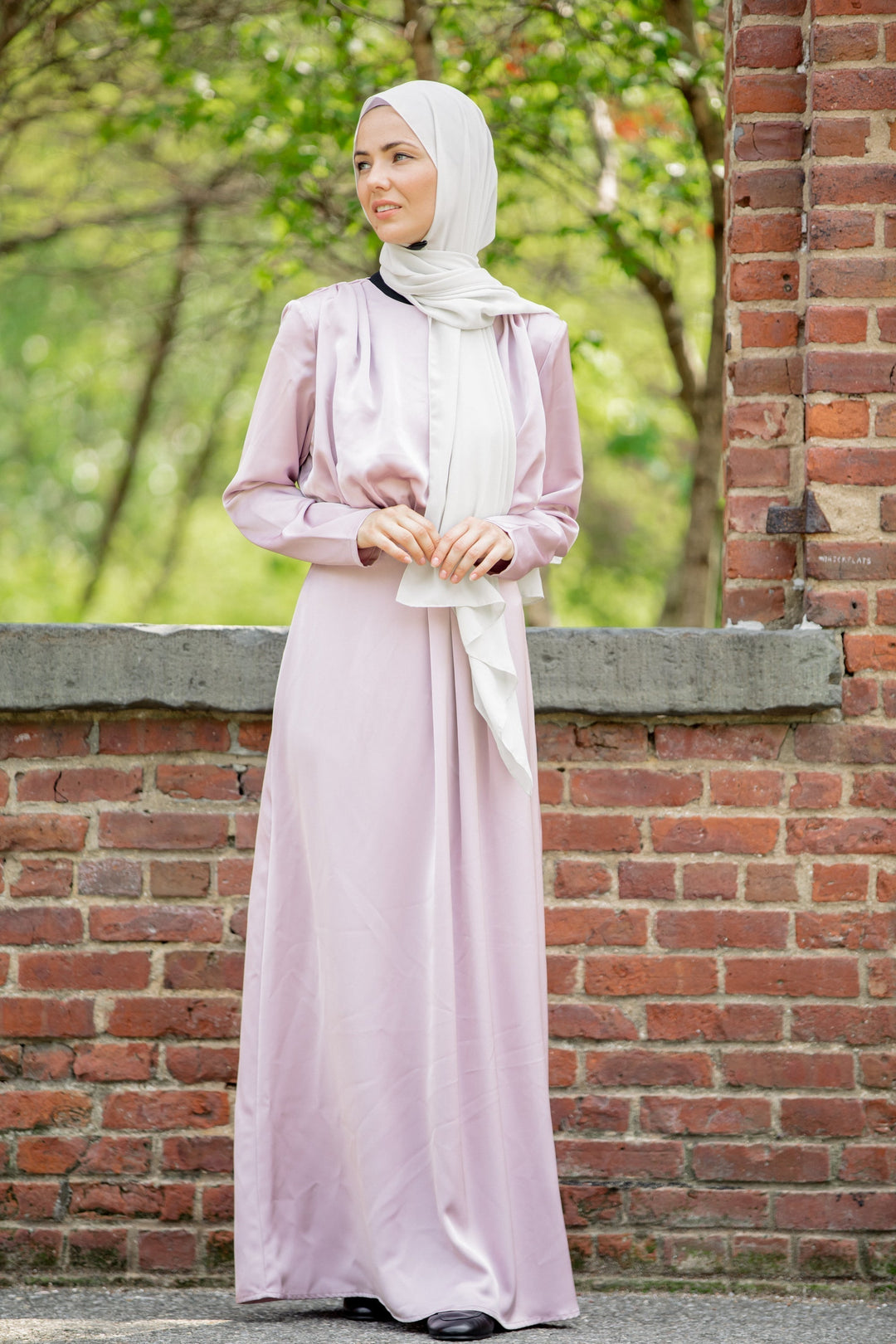 Woman wearing a modest pink Satin Pleated Maxi Dress with a white hijab