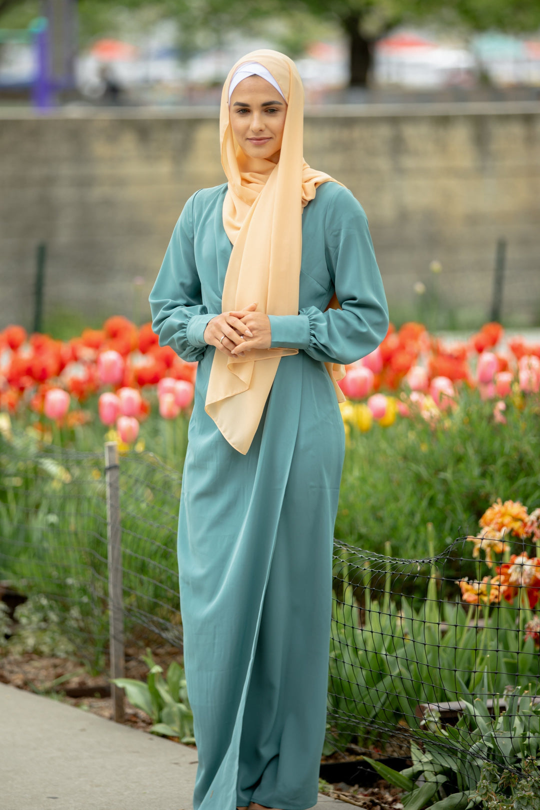 Woman in a teal hijab wearing a Sea Blue Wrap Maxi Dress with criss cross neckline