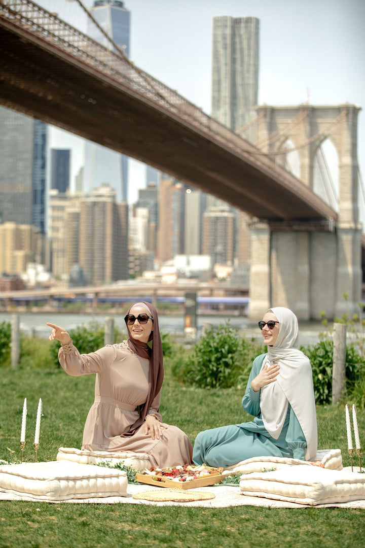 Two women in hijabs enjoying a picnic while wearing a Sea Blue Wrap Maxi Dress