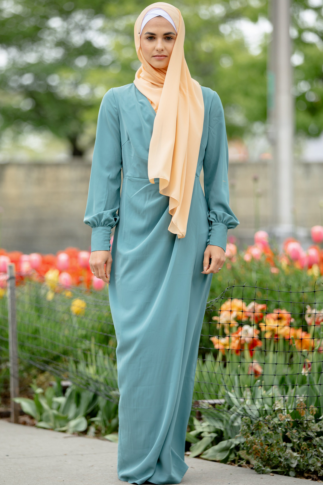 Woman in a teal Sea Blue Wrap Maxi Dress with a peach hijab