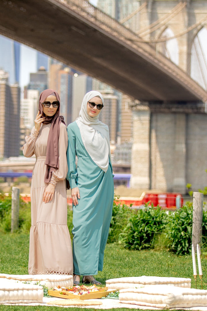 Two women in hijabs wearing a Sea Blue Wrap Maxi Dress with a criss cross neckline