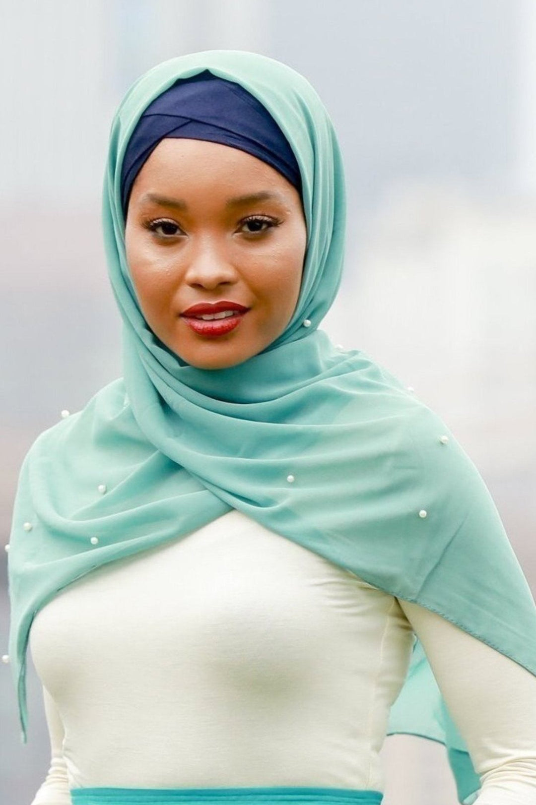 Woman in teal hijab showcasing the Sea Green Pearl Chiffon Hijab style