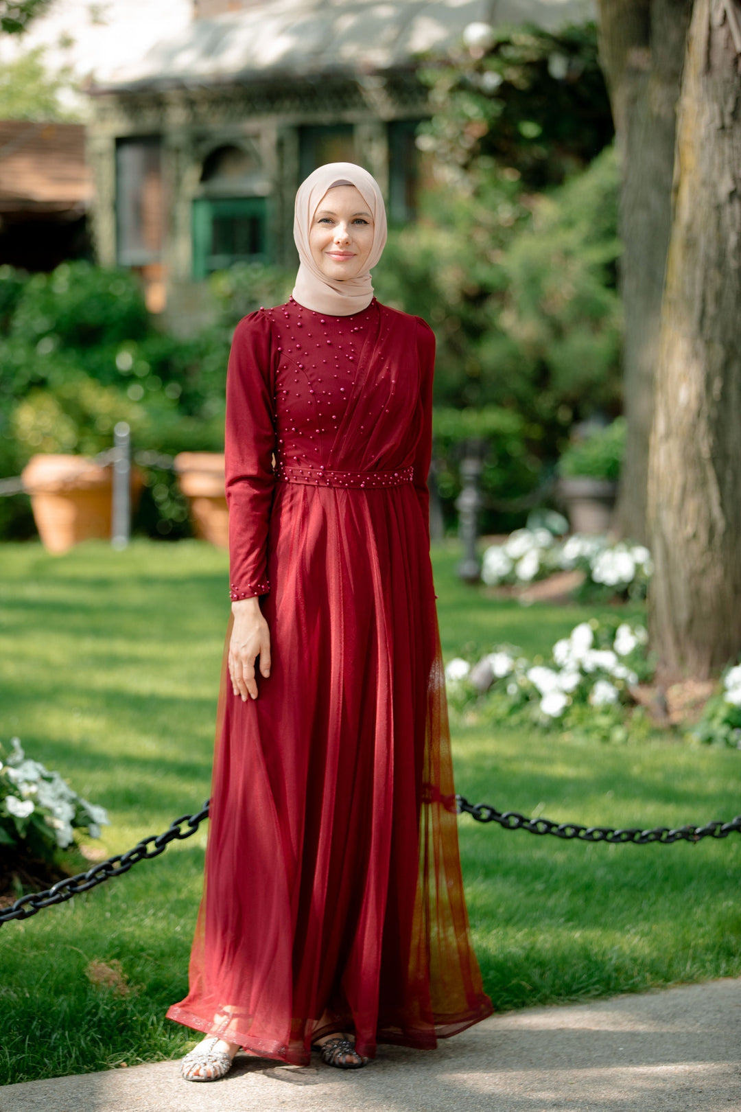 Elegant red modest maxi dress featuring side pearls, ideal for special occasions