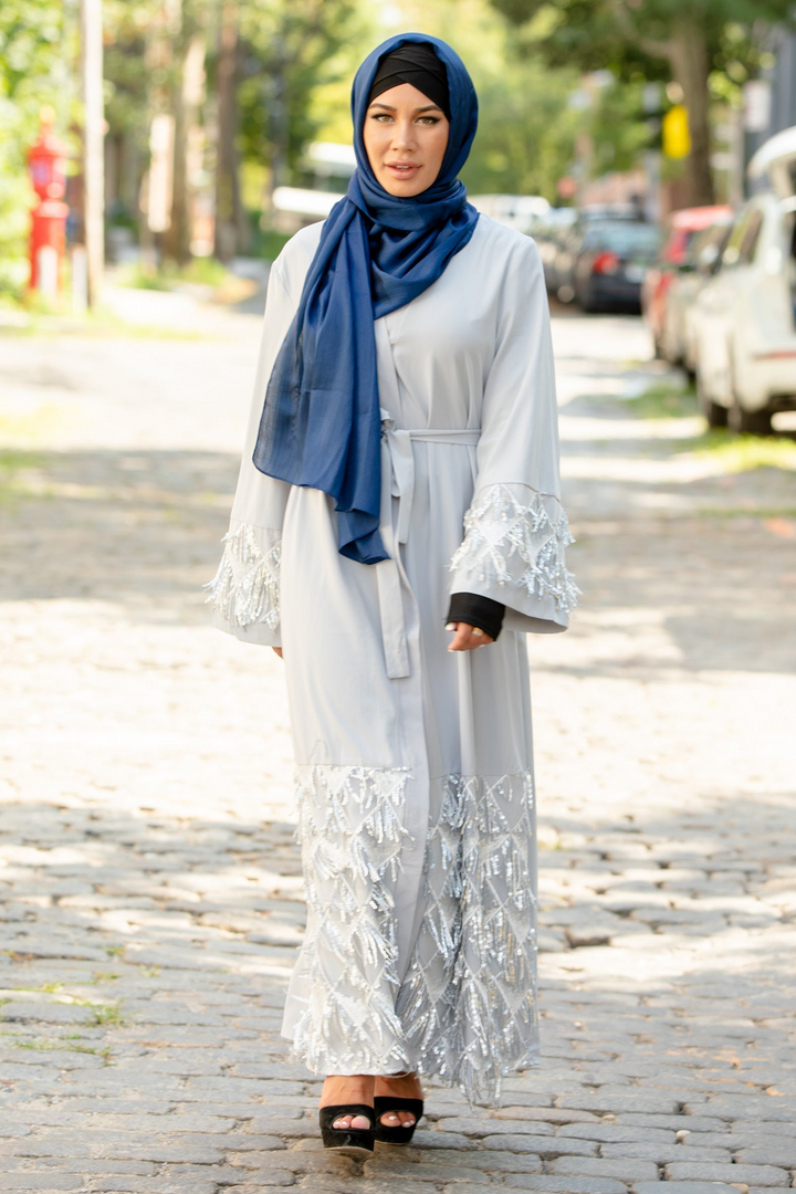 Woman wearing a blue shimmer hijab and silver sequin fringe open front abaya