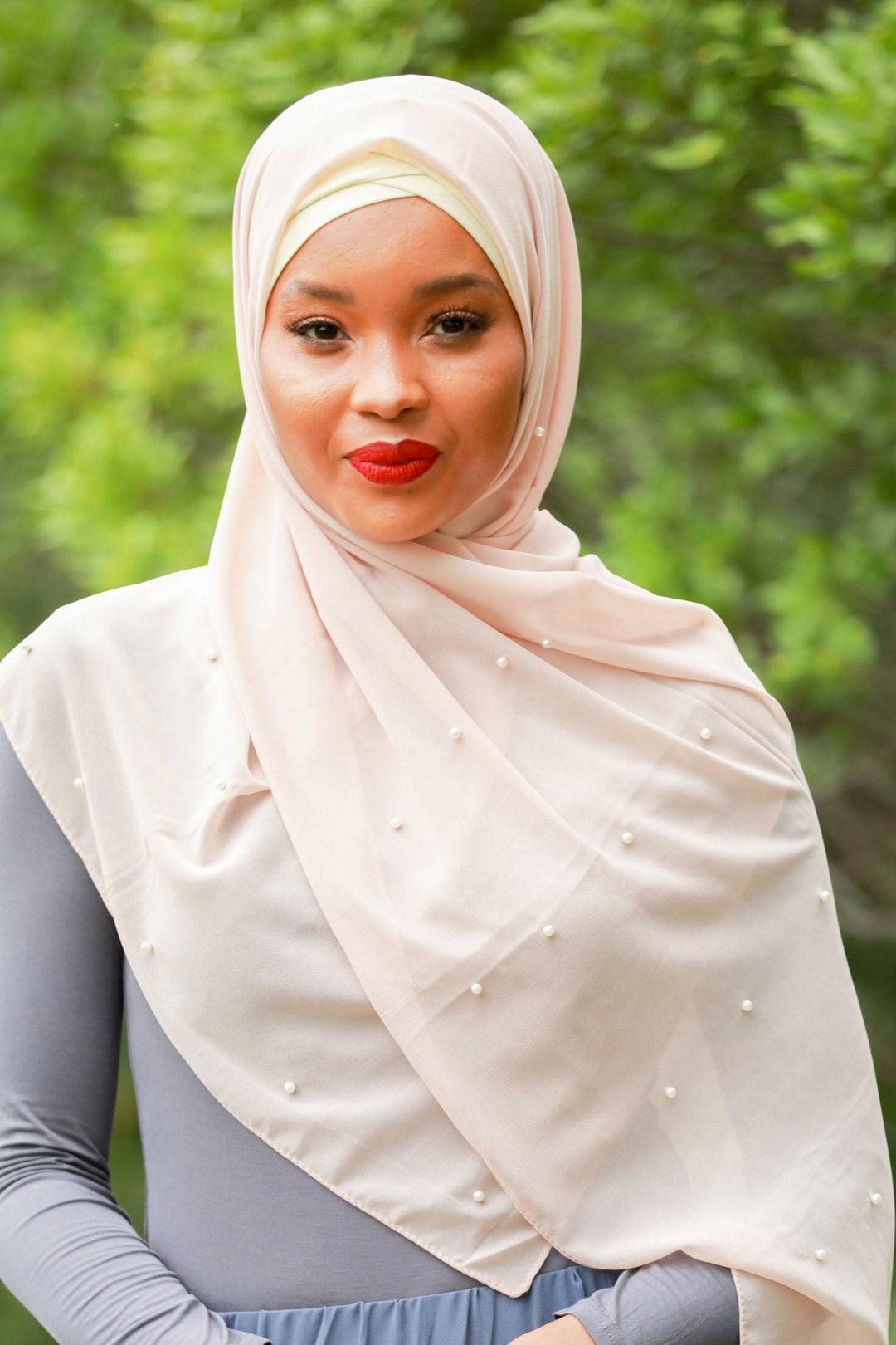 Woman wearing a Soft Pink Pearl Chiffon Hijab with elegant pearl studs