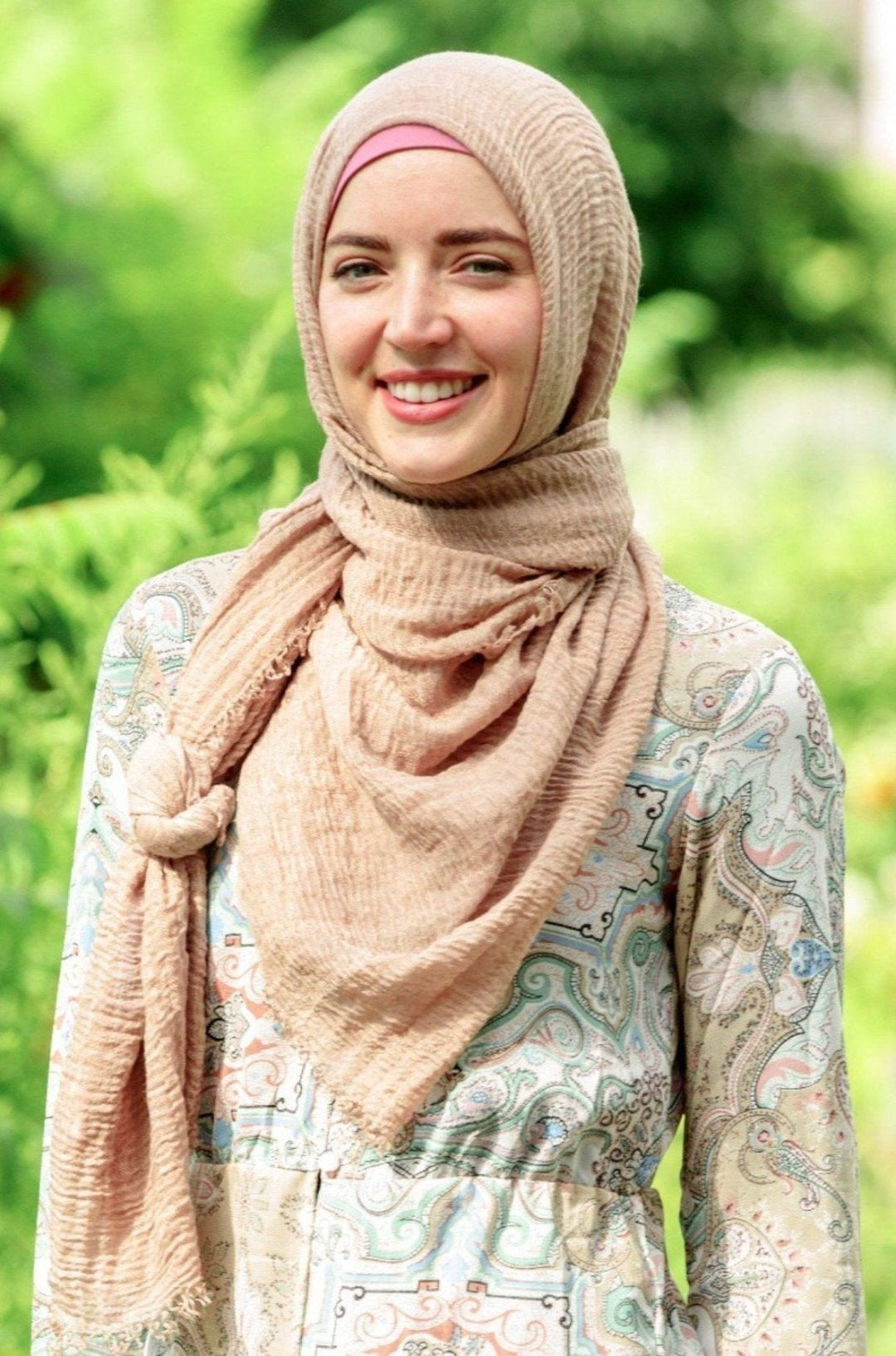 Smiling woman wearing a tan cotton hijab head scarf with elegant style